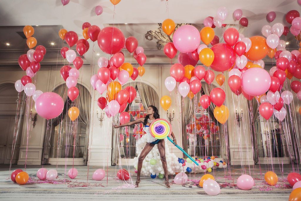 A woman posing in a room full of balloons